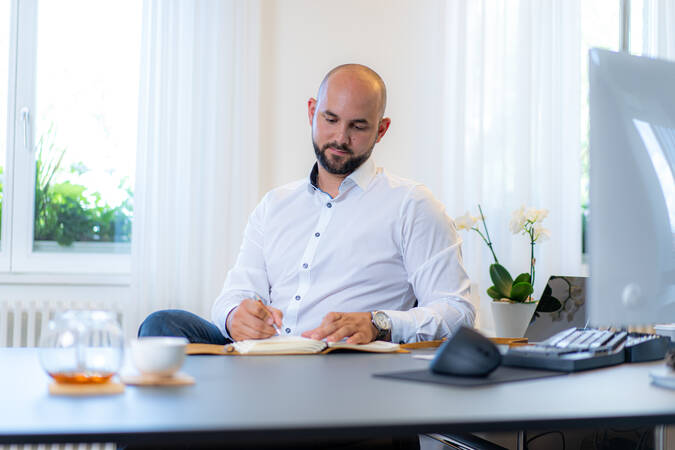 Bürgermeister Christian Abert sitzt am Schreibtisch und macht Notizen