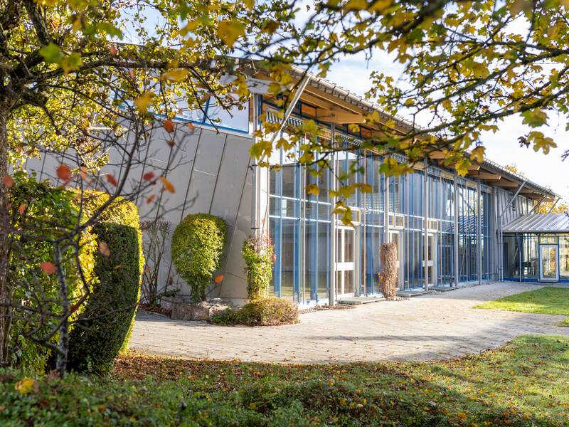 Die Mehrzweckhalle Kolbingen von Außen mit Bäumen und Hecken