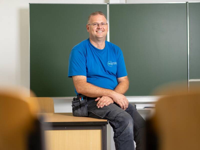 Der Hausmeister sitzt auf dem Tisch