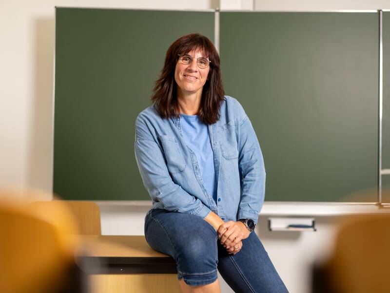 Die Schulsekretärin sitzt auf dem Tisch