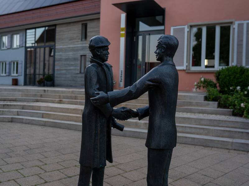 Zwei Statuen geben sich die Hand