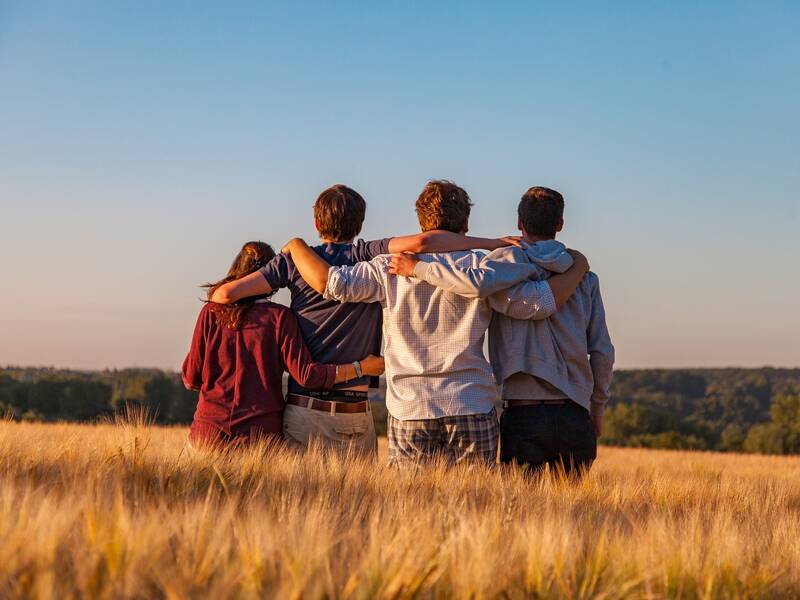 Junge Menschen stehen in einem Feld